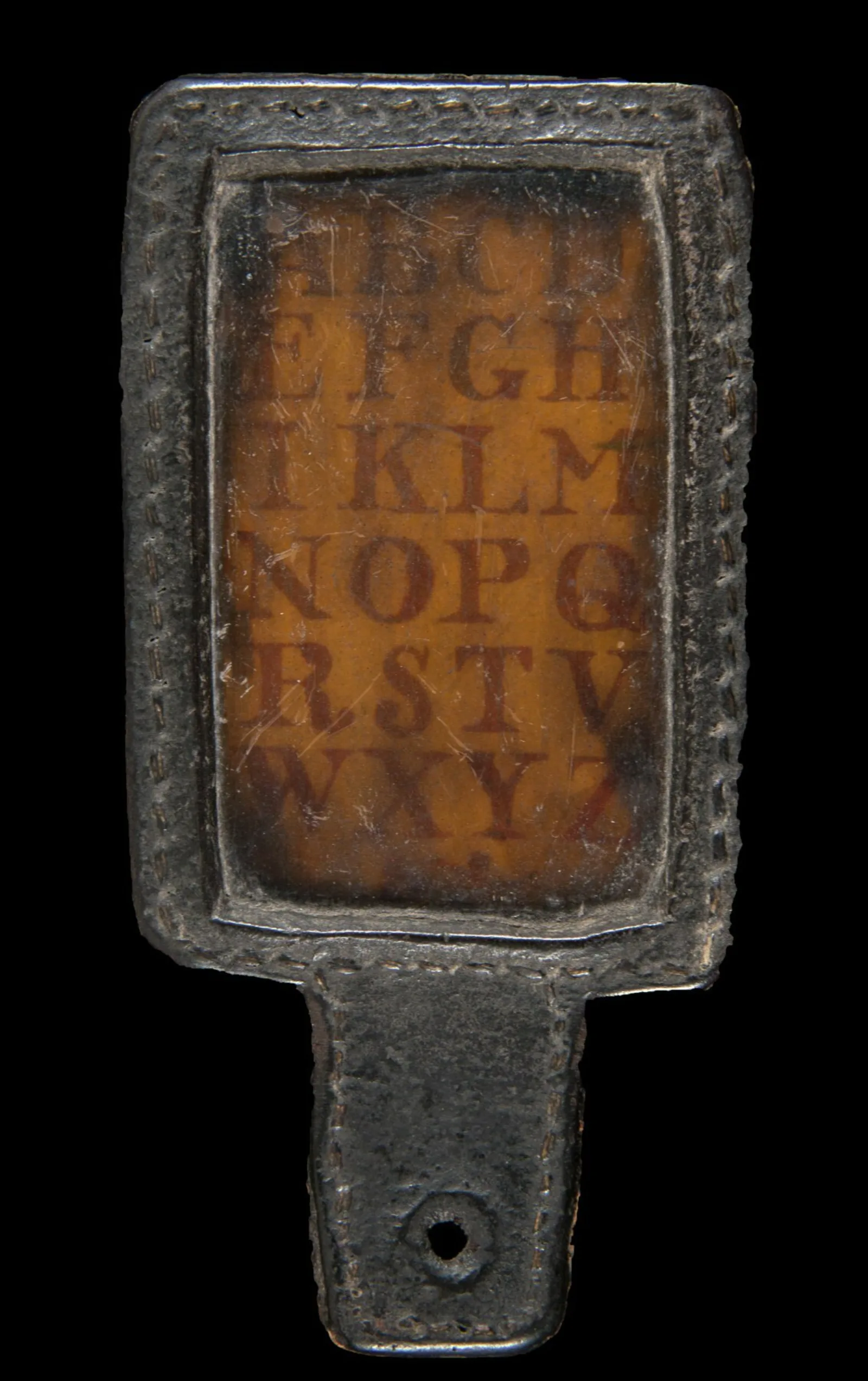 Hornbook A small wooden paddle has a transparent screen running vertically. Under the screen is the alphabet. At the base of the paddle is a small hole.