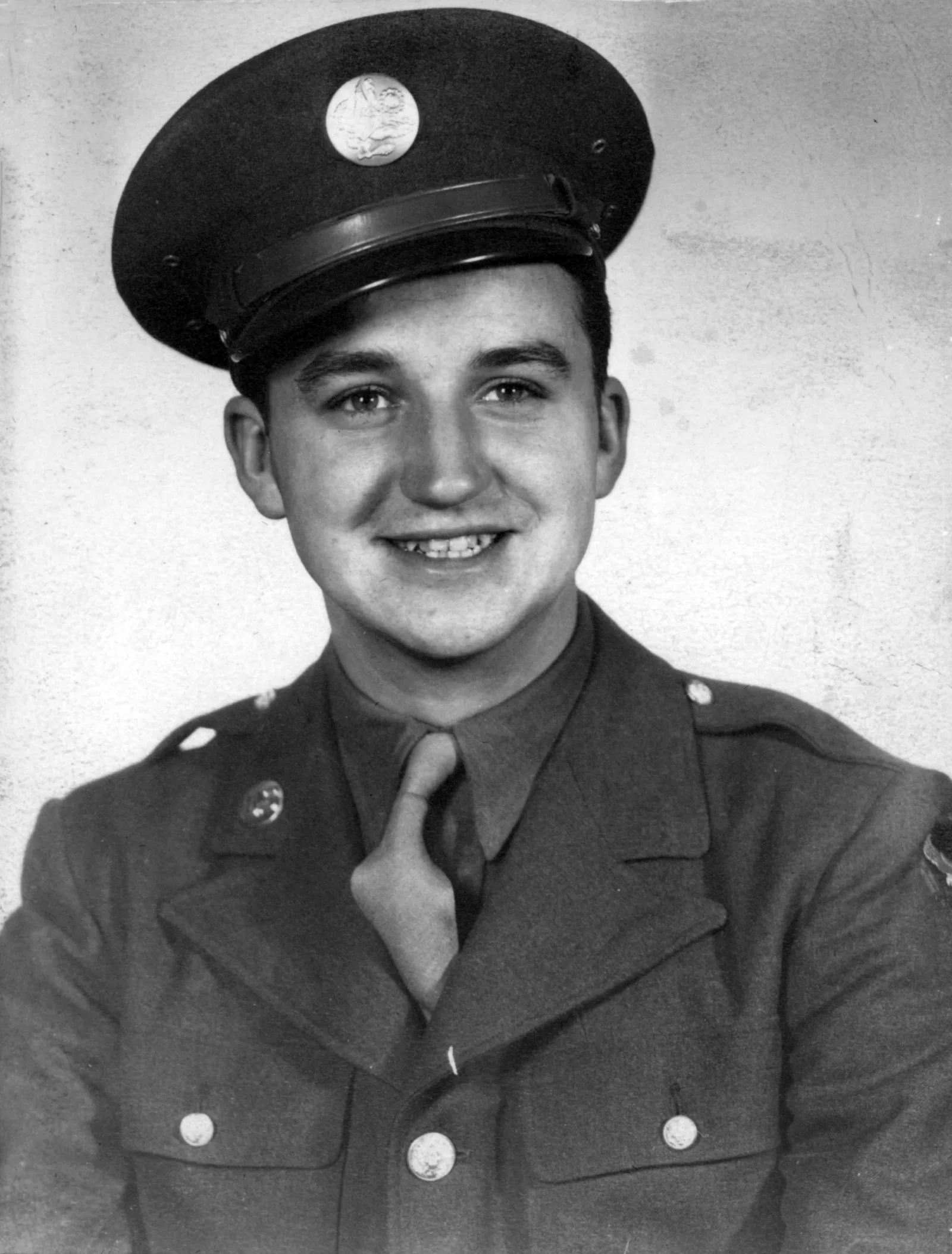 Frank “Ebner” Gartz A young man smiles in military uniform while serving overseas during World War II